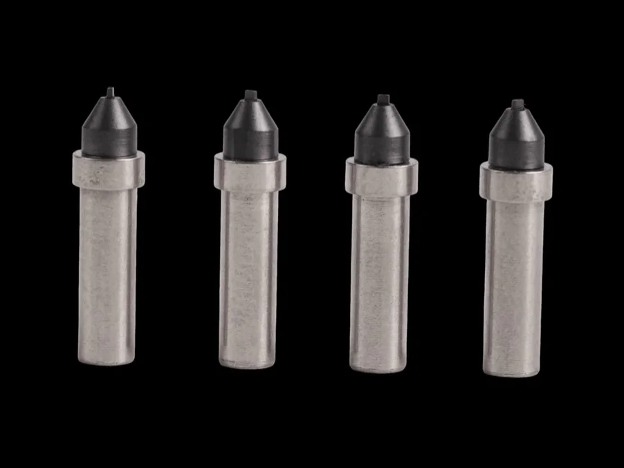 Four tungsten carbide pick-up nozzles with pointed tips.